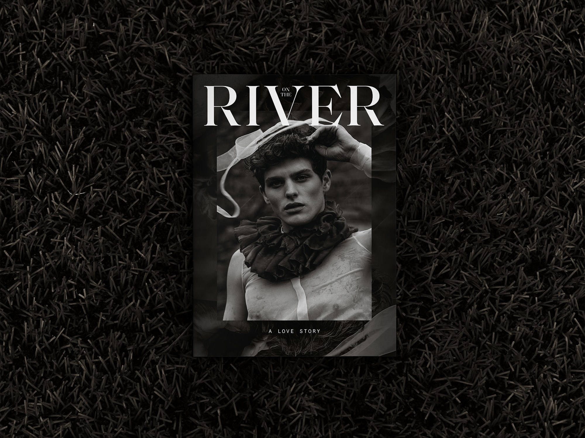 Fronte copertina dell'editoriale On the River posizionato sull'erba, inquadrato frontalmente e dall'alto
