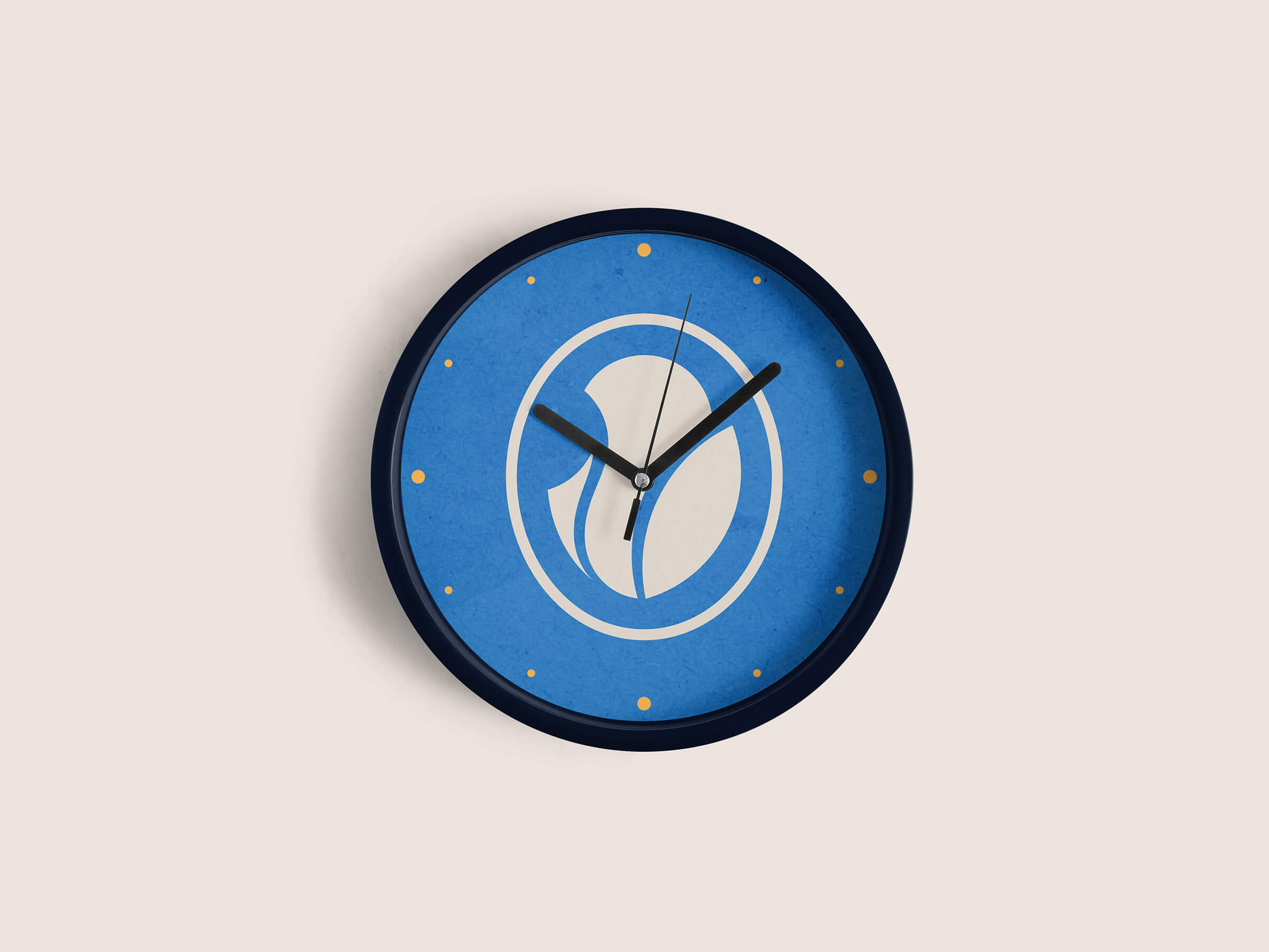Wall clock with a blue face featuring a white capsule-shaped design and small orange dots marking the hours, with black hour and minute hands.