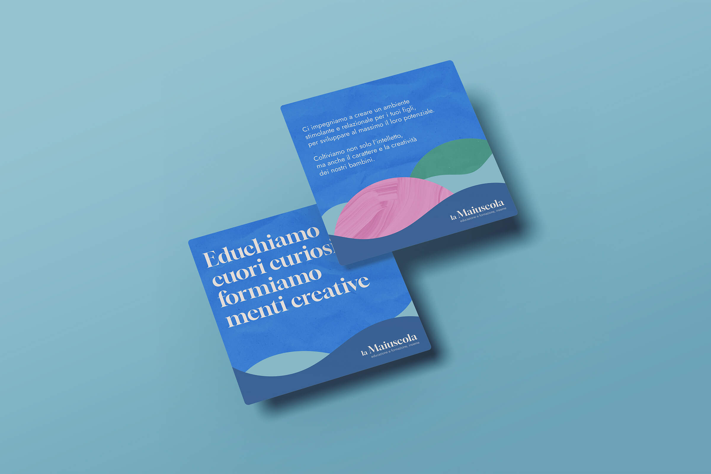 Two blue square cards with Italian text and colorful abstract shapes, promoting 'la Maiuscola' education and training.